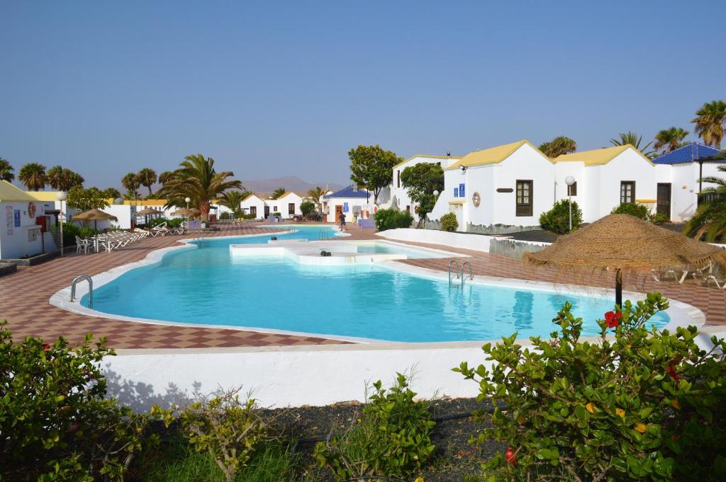 uma grande piscina num resort com casas em Bungalow Tetir in Caleta de Fuste em Caleta de Fuste