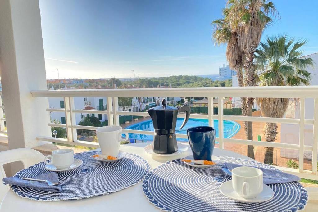 a table with a tea pot and cups on a balcony at PUERTAS AL MAR in Cala en Blanes