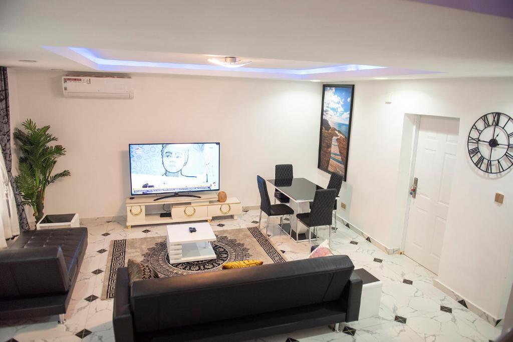 En tv och/eller ett underhållningssystem på Cc & Cg Homes Luxury 3 Bedrooms House - 24Hrs Power