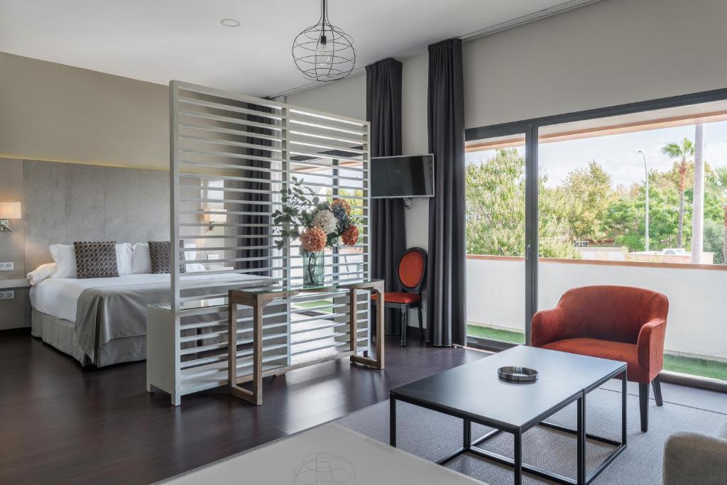 um quarto com uma cama e uma sala de estar em Sevilla Green Suites em Alcalá de Guadaira