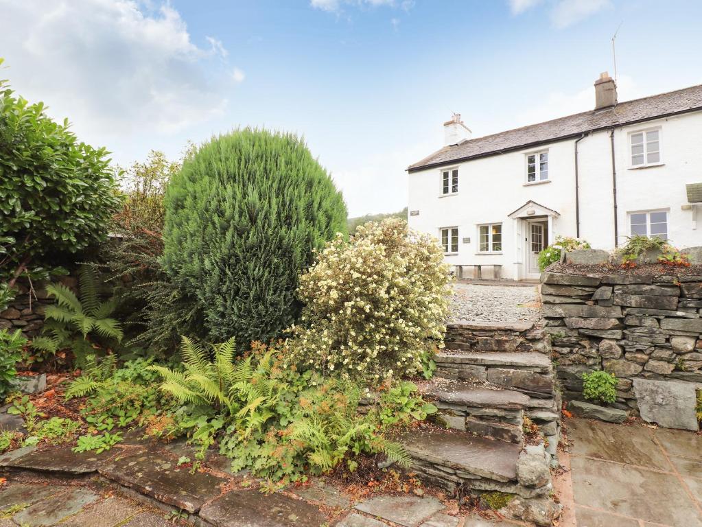 a garden in front of a white house at Hilber Cottage in Ambleside