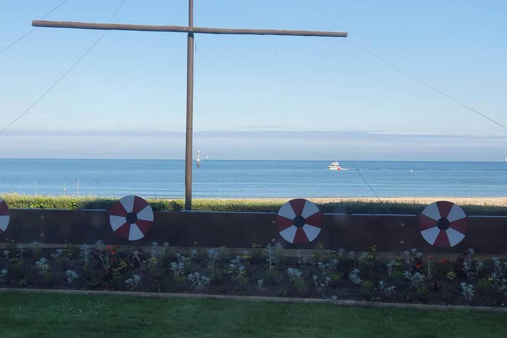 a fence with red and white arrows on it near the ocean at Appartement, Les TEMPLIERS, RDC VUE MER PROCHE CENTRE VILLE in Houlgate
