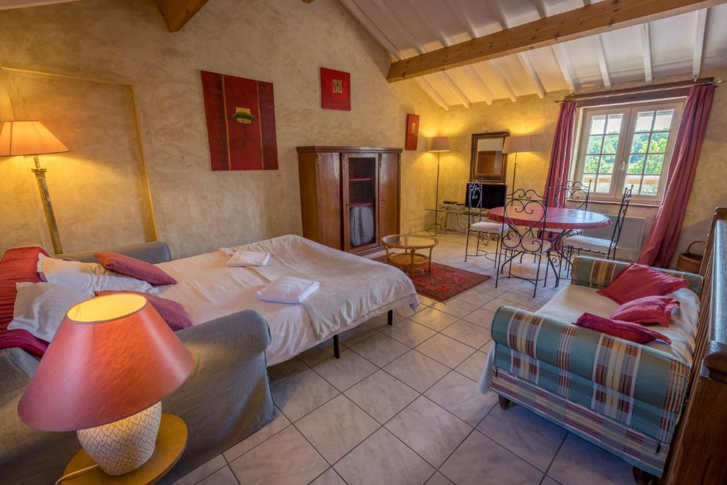 a bedroom with two beds and a table and chairs at Gites Le Clos de Saires in Saires