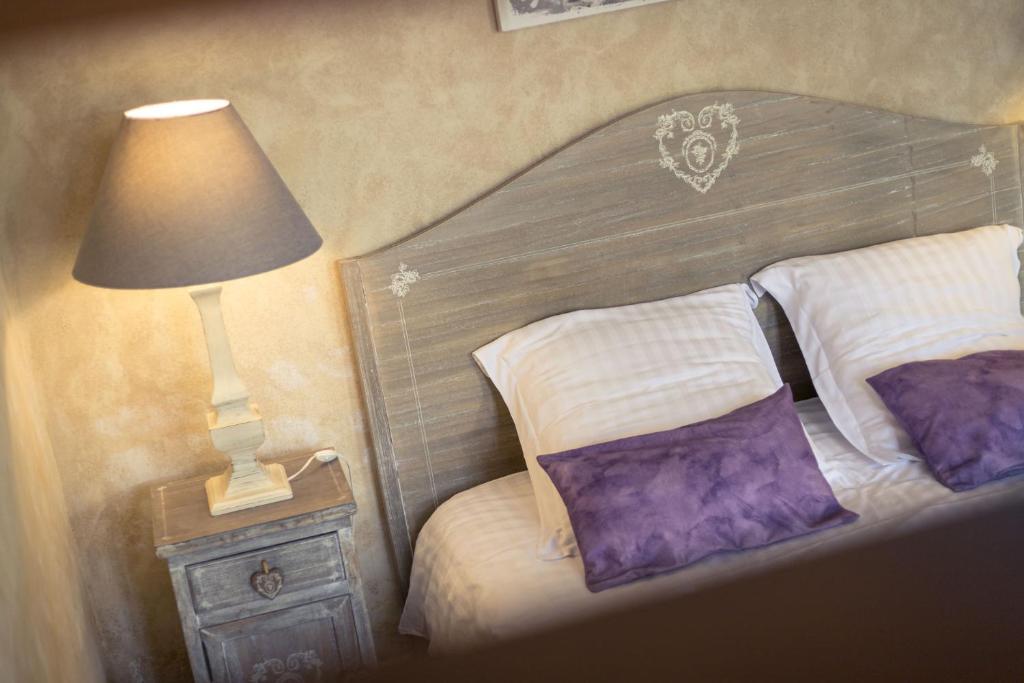 a bedroom with a bed with a lamp on a night stand at Gites Le Clos de Saires in Saires