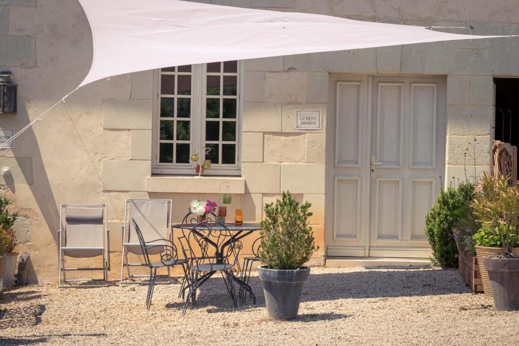 a table and chairs in front of a building at Gites Le Clos de Saires in Saires