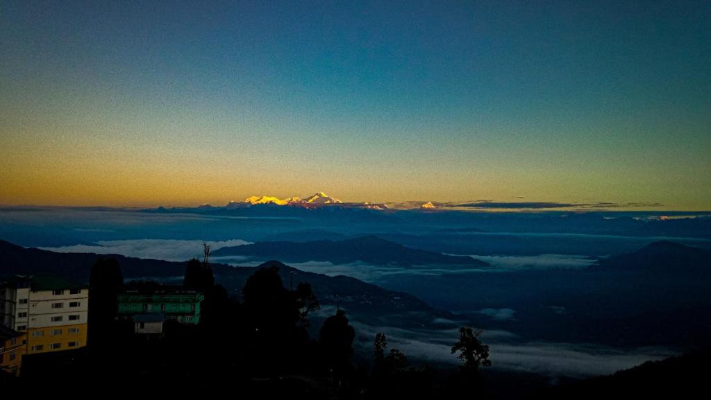 Rishop - Zivaan Stay في Rishop: اطلاله على جبل في السماء مع الغيوم