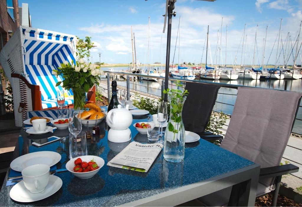 a table on a balcony with a view of a marina at Ostsee - Maisonette - Appartement Nr 53 "Schöne Aussicht" im Strand Resort in Heiligenhafen