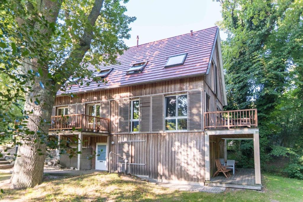 阿伦斯霍普Landhaus DADDELDU Whg. V-D2 (hinten)的一座带甲板和树的房子