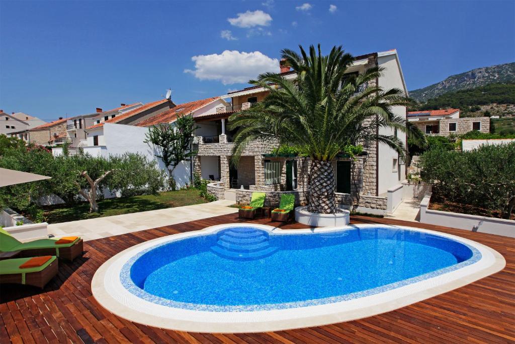 a swimming pool in the yard of a house at Apartments Diana - NEW heated pool in Bol