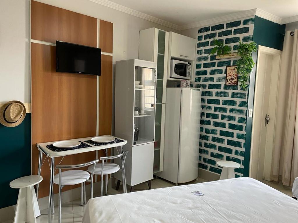 a room with a bed and a kitchen with a refrigerator at CTC Araras in Caldas Novas