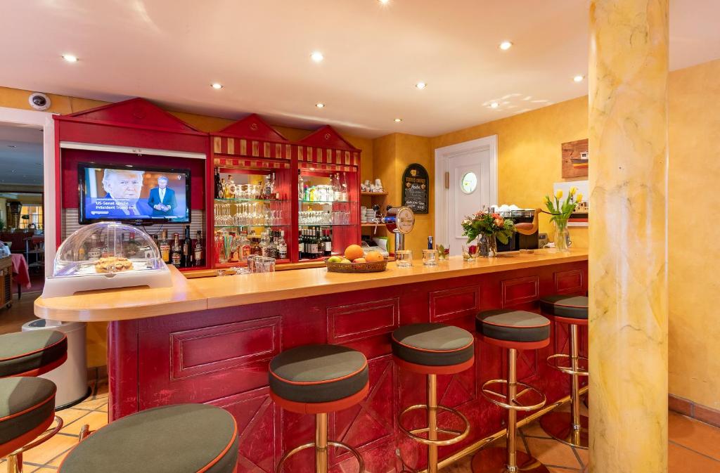 a bar in a restaurant with stools at a counter at Strandhotel Sylt Westerland in Westerland