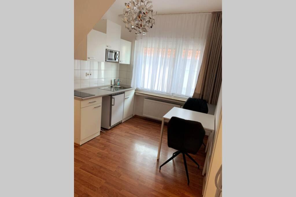 a kitchen with white cabinets and a table and chairs at Ferienwohnung in Wiesbaden in Wiesbaden