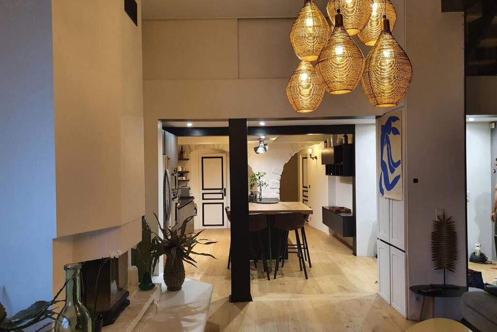 una cucina e una sala da pranzo con tavolo e luci di Loft de type industriel et spacieux a Nizza