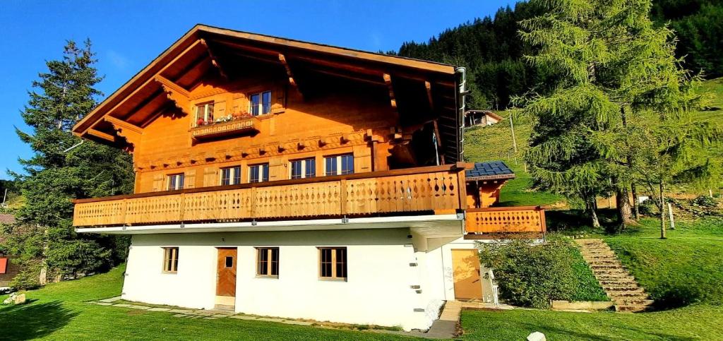 a house with a balcony on top of it at Chalet bois soleil in Les Mosses