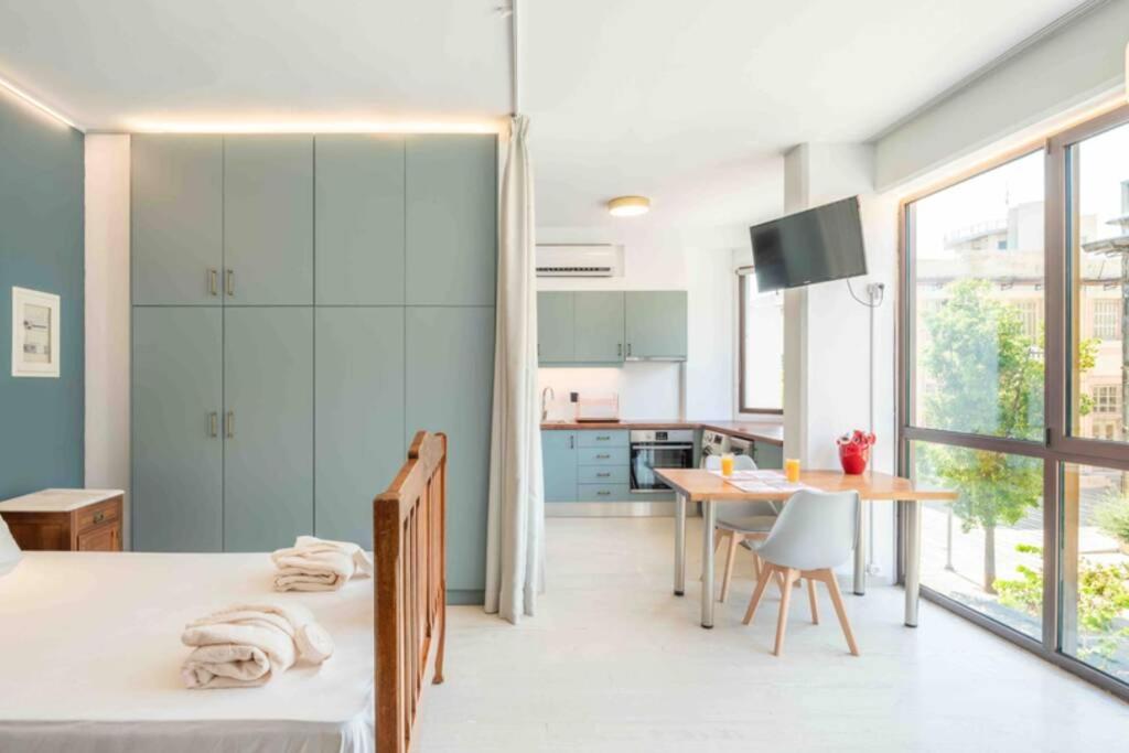 a room with a bed and a table and a kitchen at Urban View Studio in Heraklio