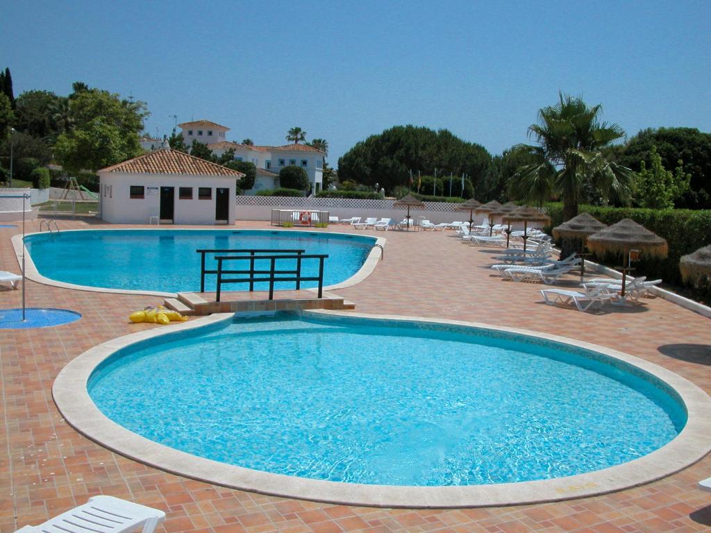 a large swimming pool with chairs and umbrellas at Baiona Club Villa 19 in Porches