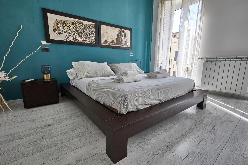 um quarto com uma cama com uma parede azul em Modern apt facing St Peter's and Vatican Museums - myPad in Rome em Roma
