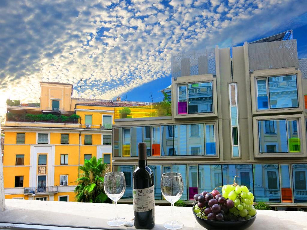 een fles wijn op een tafel met wijnglazen bij NIK Rooms in Rome
