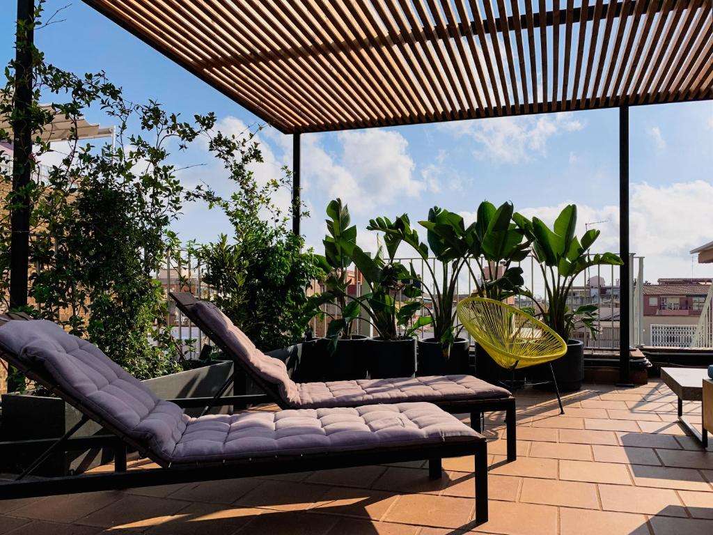 eine Terrasse mit 2 Sofas und Stühlen auf einer Terrasse in der Unterkunft Incredible 2BR Penthouse with Urban Rooftop Garden in Barcelona