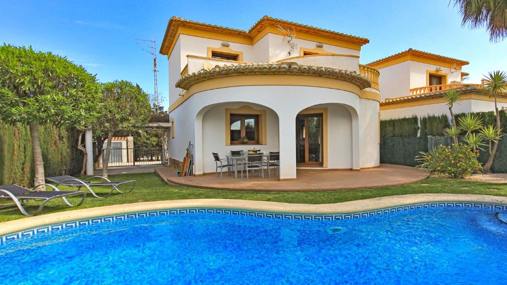 Villa con piscina frente a una casa en Villa El Palmar, en Denia