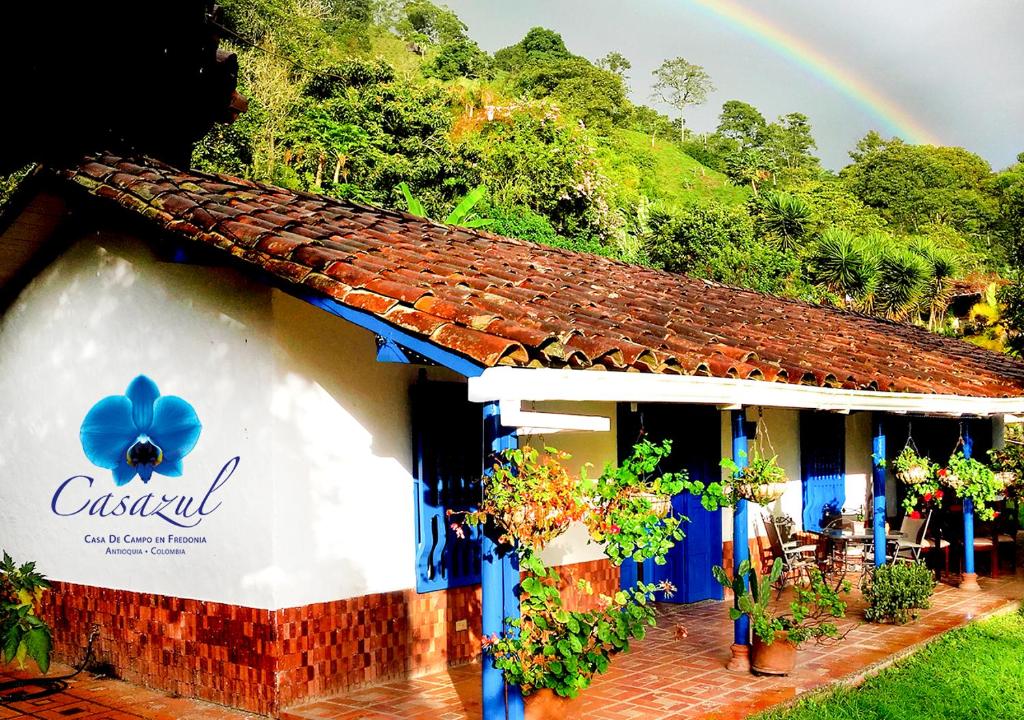 a house with a rainbow in the background at Casazul Casa de Campo in Fredonia