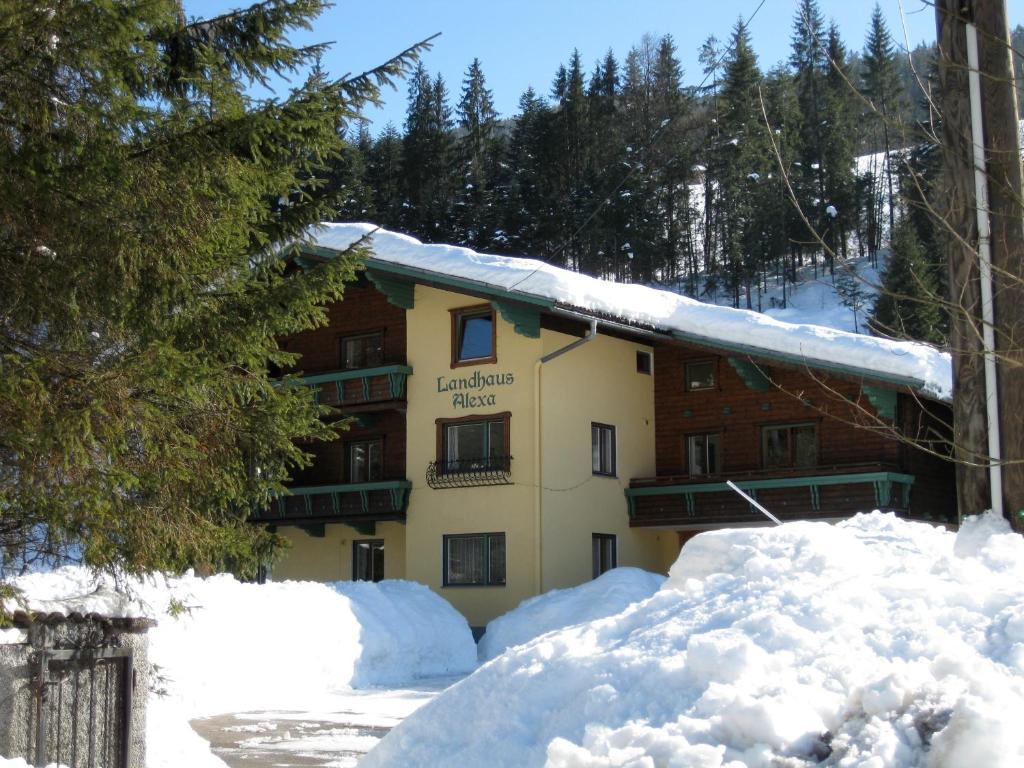 un edificio cubierto de nieve con nieve apilada en Landhaus Alexa, en Eben im Pongau