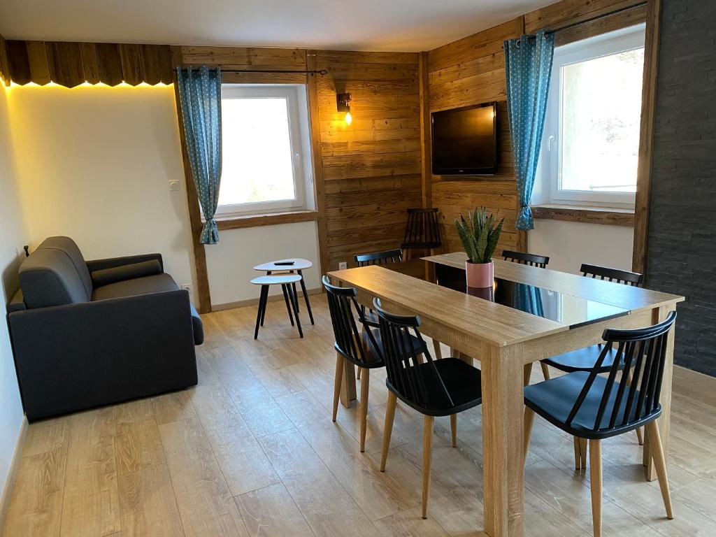 sala de estar con mesa de comedor y sillas en Le cocon d’Emma, en La Bresse