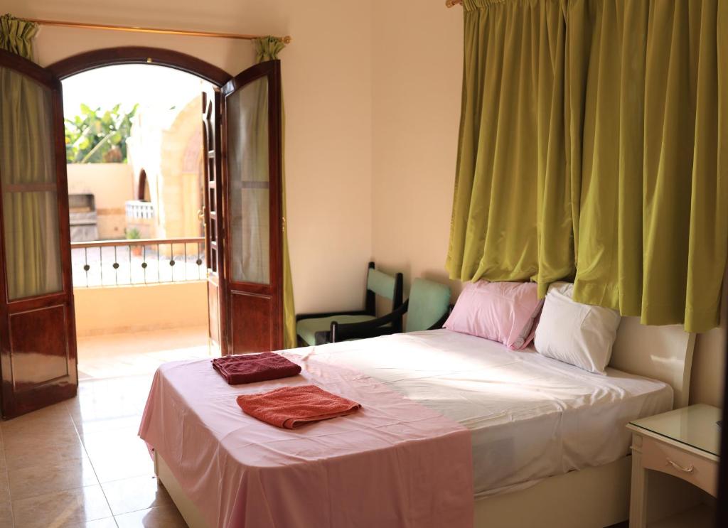 um quarto com uma cama com uma janela e uma cadeira em DREAM ISLAND Hotel em Luxor