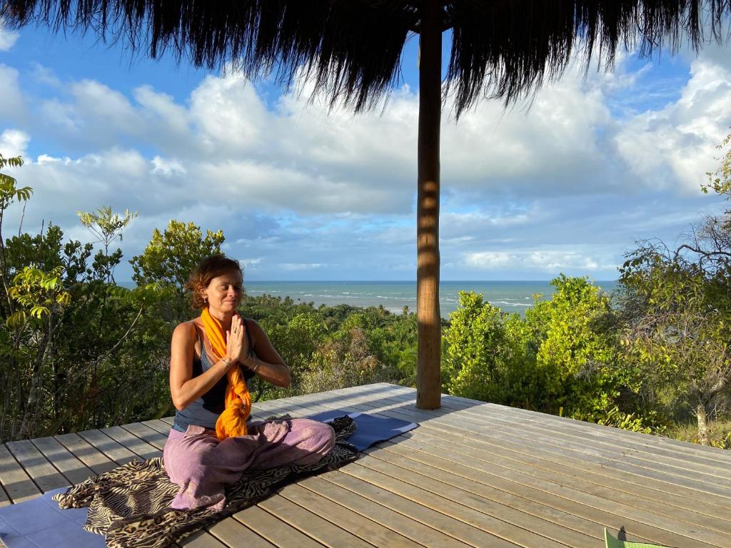 Eine Frau, die auf einem Deck sitzt und Meditation macht. in der Unterkunft Morere Jungle Lodge in Moreré