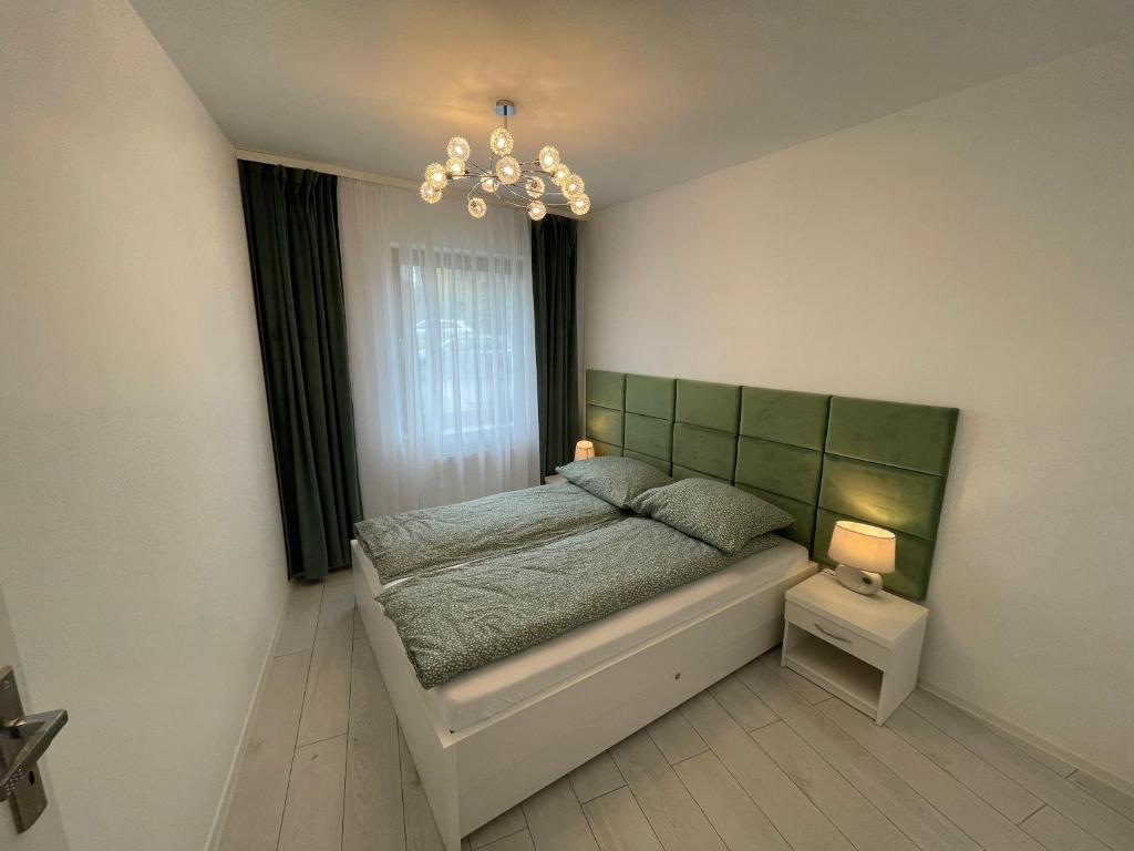 a bedroom with a bed and a chandelier at Apartament Biała Róża in Szklarska Poręba