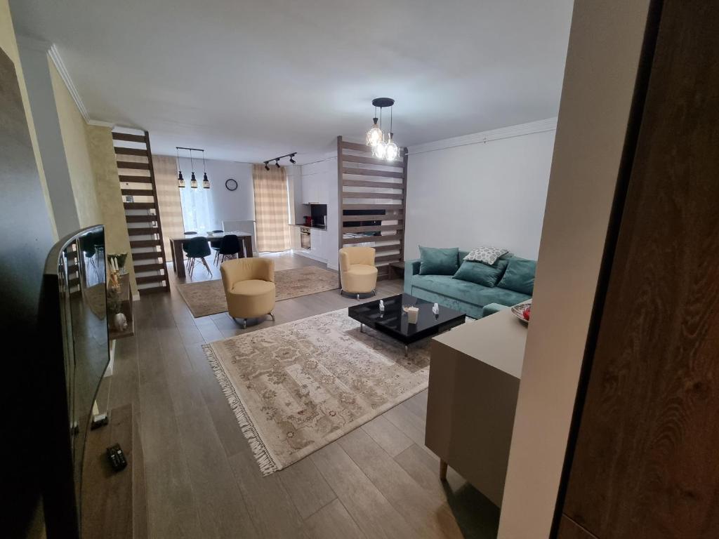 a living room with a green couch and a living room with at Apartament SUPERB in regim Hotelier- Arad Plaza in Arad