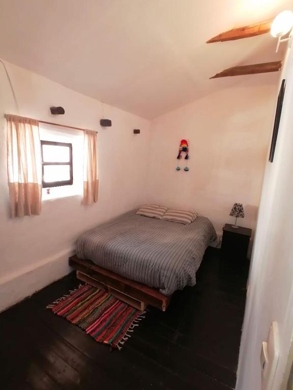 una camera da letto con un letto con un cappello a Babbo Natale sul muro di Asiriq Wasi Guest House a Cuzco