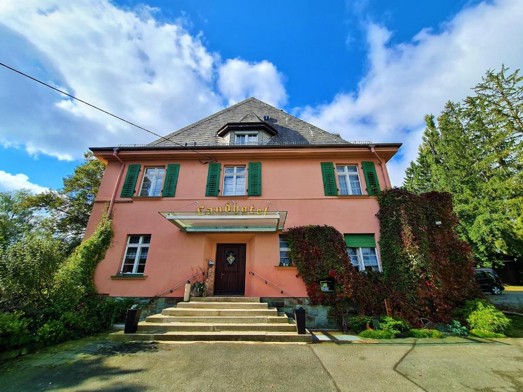 een roze gebouw met een trap ervoor bij Landhotel in Mühltroff