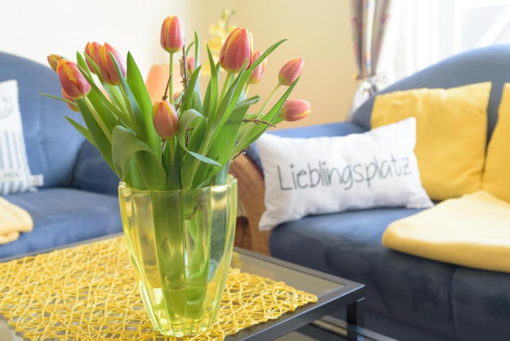 een vaas met bloemen op een tafel in een woonkamer bij Revenstorf Wohnung 2 in Grömitz