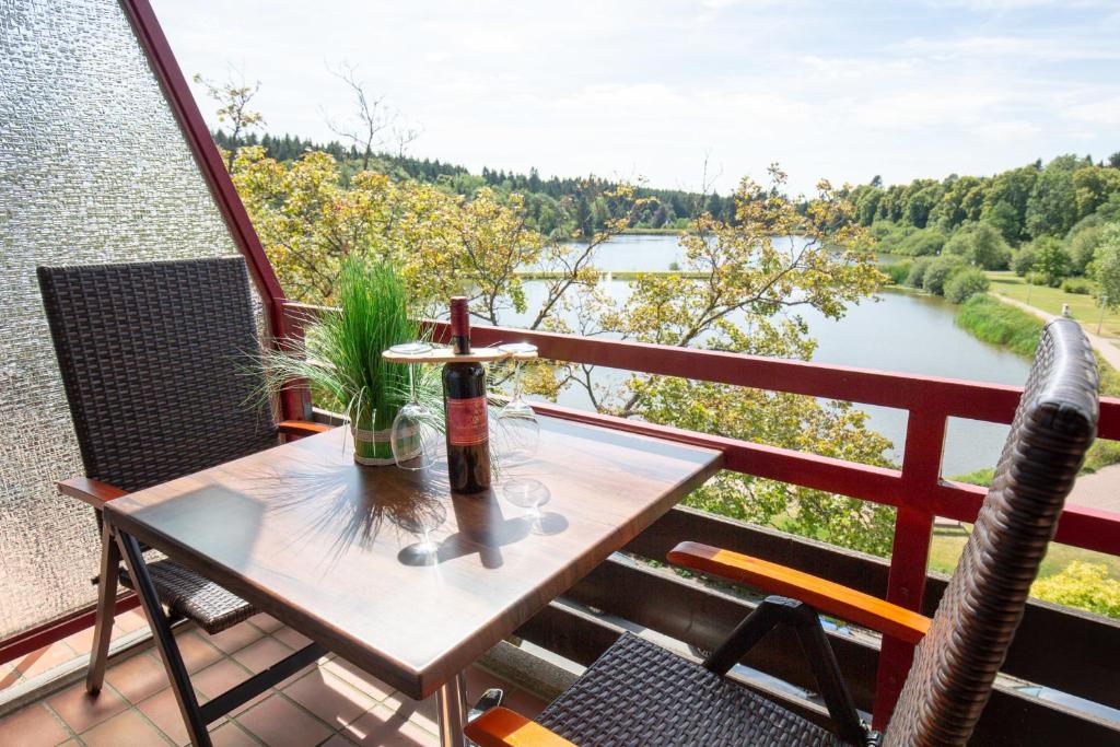 een tafel op een balkon met uitzicht op een rivier bij Sweet Harmony Apartment mit Seeblick zum Genießen in Hahnenklee-Bockswiese