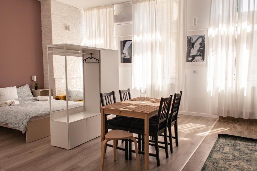 comedor con mesa, sillas y cama en Sunny Studio Apartment, en Iaşi