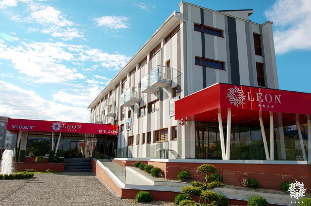 a building with red signs on the front of it at Hotel Leon & Spa in Arad