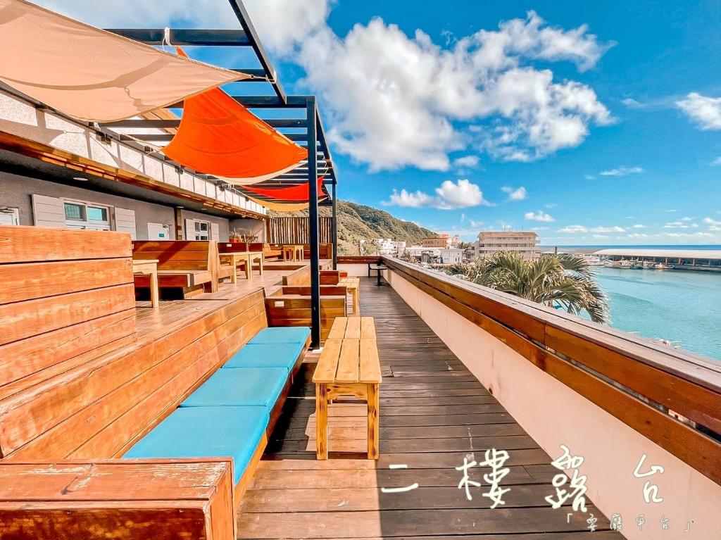 een terras van een restaurant met banken en uitzicht op de oceaan bij Green Island 9 Padi in Green Island