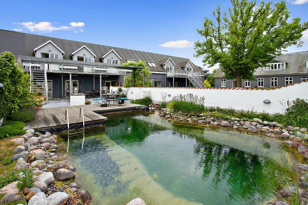 einen Pool mit Wasser vor einem Haus in der Unterkunft Holberggaard Apartments in Vordingborg