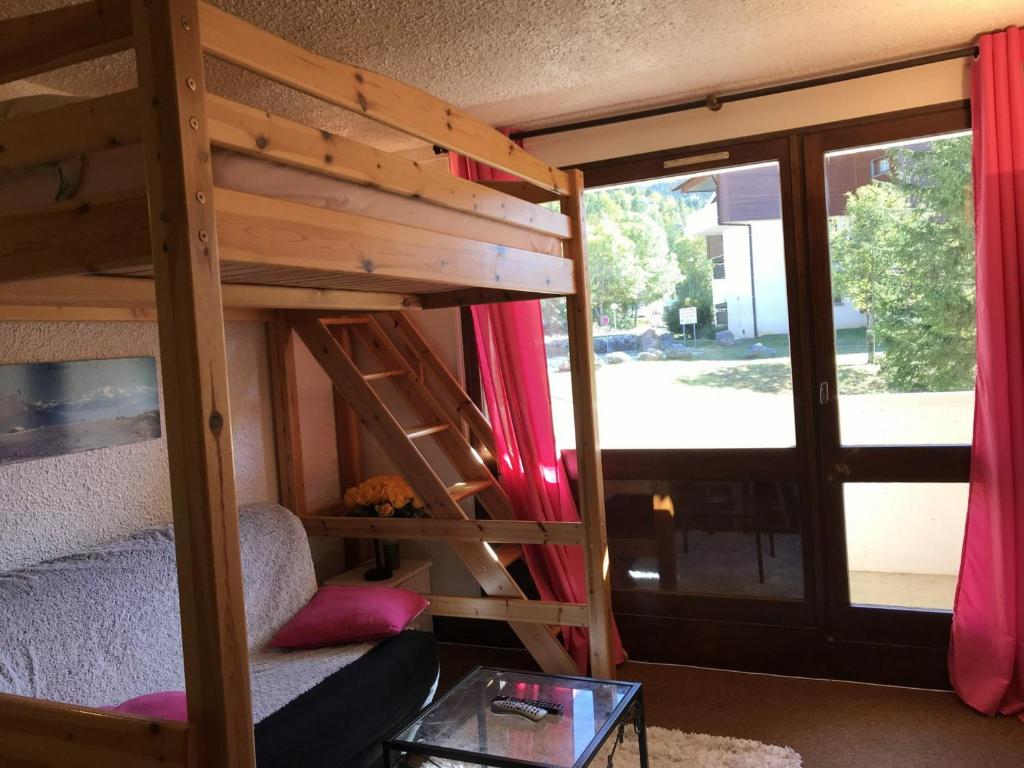 a room with a bunk bed with a couch and a table at Studio Corrençon-en-Vercors, 1 pièce, 4 personnes - FR-1-515-83 in Corrençon-en-Vercors