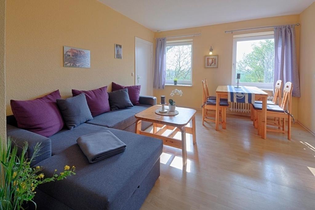 a living room with a couch and a table at "Ferienhof Seelust" Ferienwohnung Nelke in Gammendorf