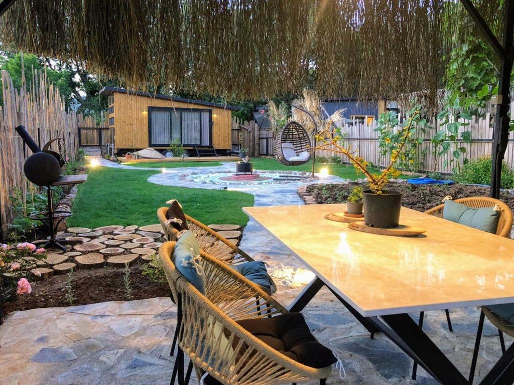 a patio with a table and chairs in a yard at Tiny house kayaköy Nar in Fethiye