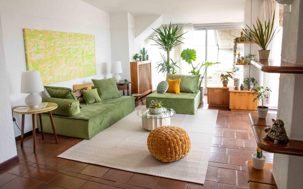una sala de estar con sofás verdes en Skyline - Un Attico da Sogno, en Desenzano del Garda