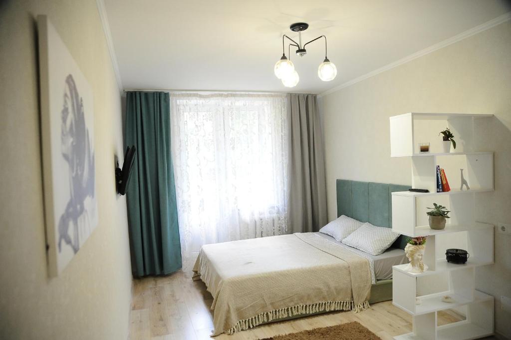 ein kleines Schlafzimmer mit einem Bett und einem Fenster in der Unterkunft Cozy Apartment Center in Chişinău