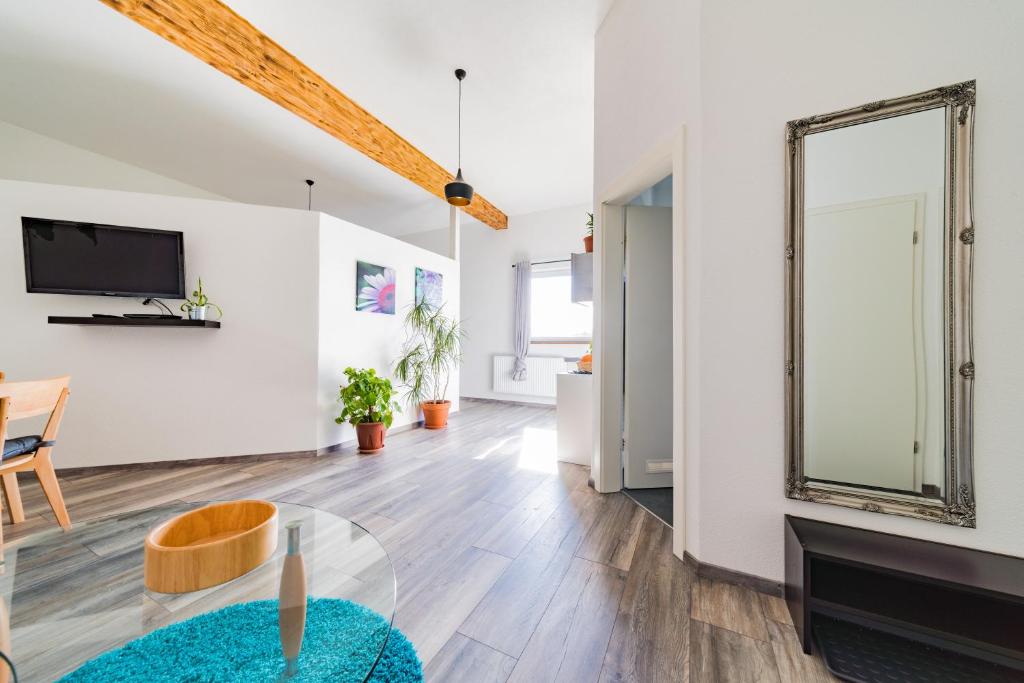 a living room with a table and a tv at Apartment 4 an der Messe Friedrichshafen in Friedrichshafen