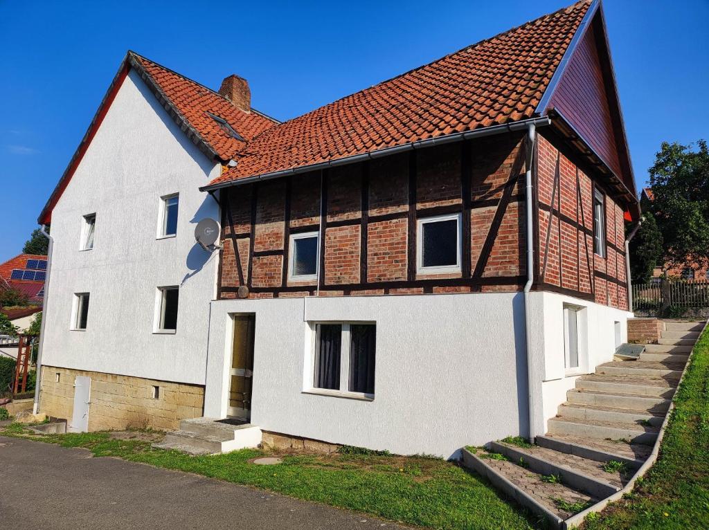 a large white house with a red roof at Monteurzimmer Ferienwohnung in Bad Gandersheim