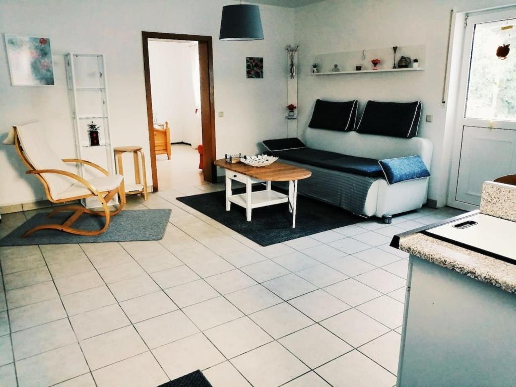 ein Wohnzimmer mit einem Sofa und einem Tisch in der Unterkunft 76 qm Whg im EG Haus-Wohlfühloase vor der Haustür in Gladenbach