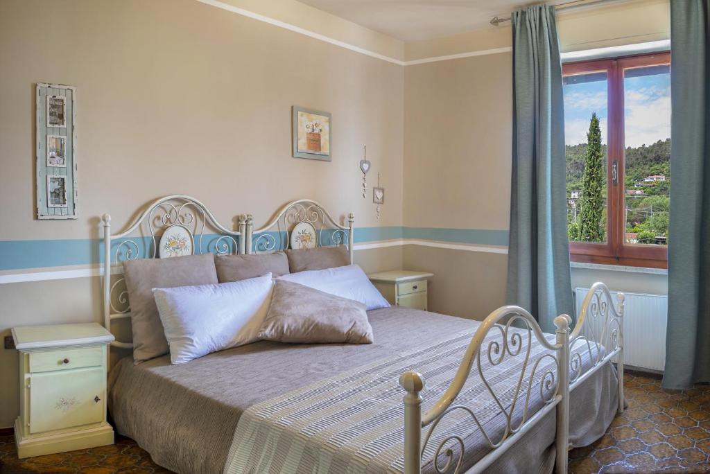Schlafzimmer mit einem Bett und einem Fenster in der Unterkunft Villa Ori B&B in Bocca di Magra