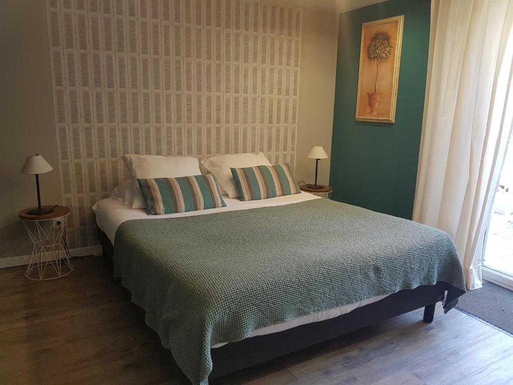 a bedroom with a large bed with two pillows at LES LUPINS in Étretat