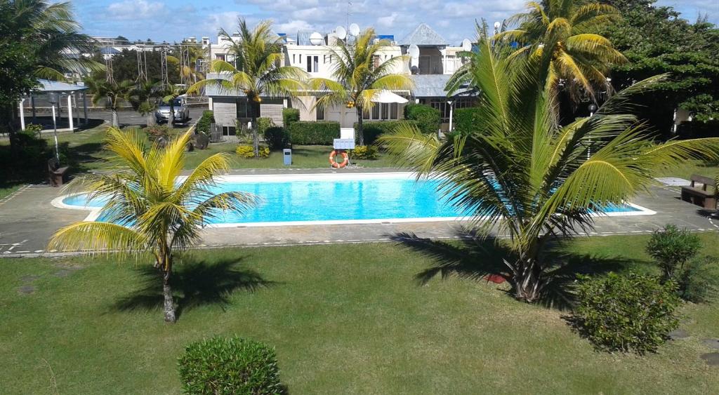 格蘭貝伊的住宿－Aquamarine - Grand Baie - 4 chambres - Piscine，享有棕榈树游泳池的顶部景致
